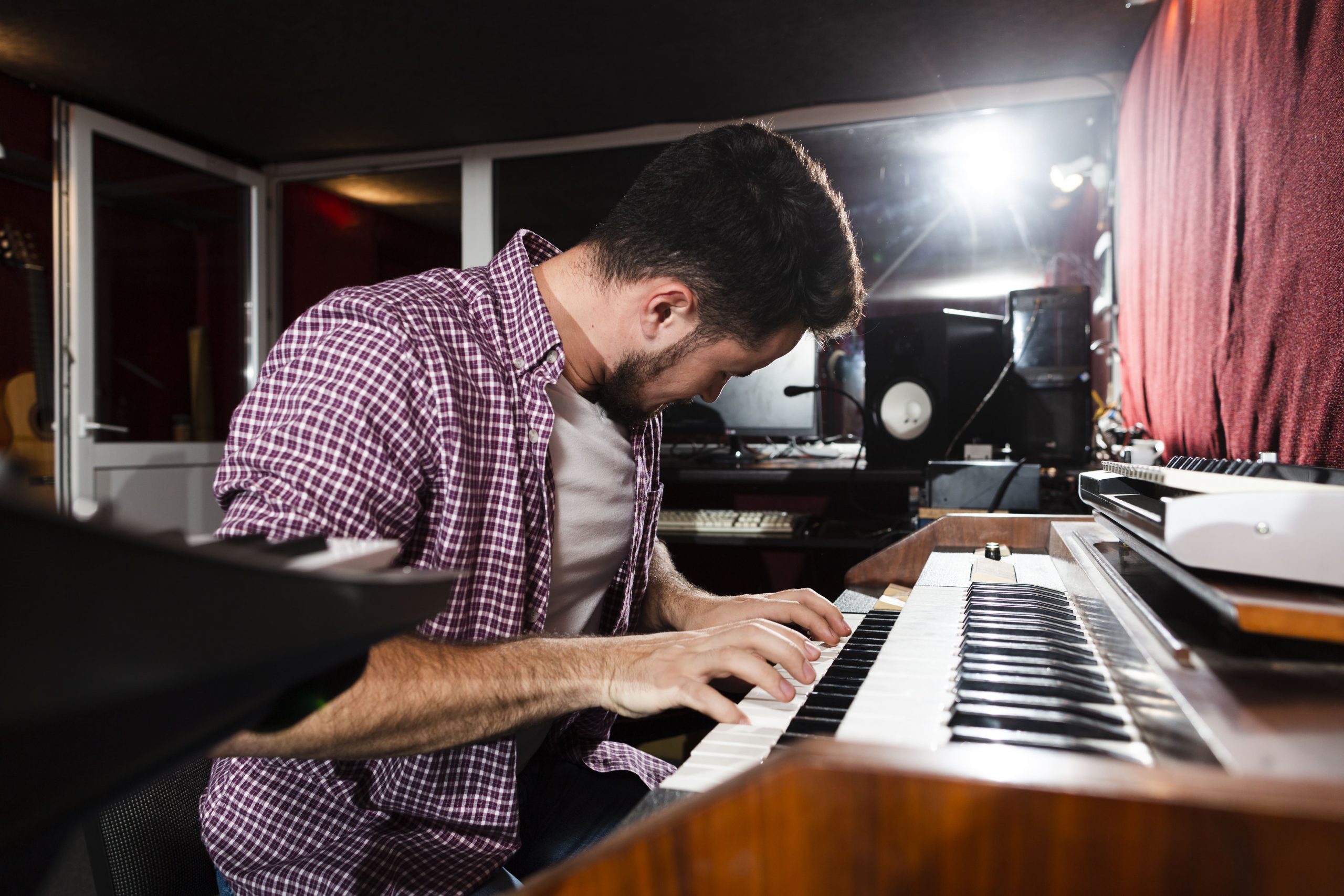 chico tocando el piano en estudio de grabacion con puerta acustica